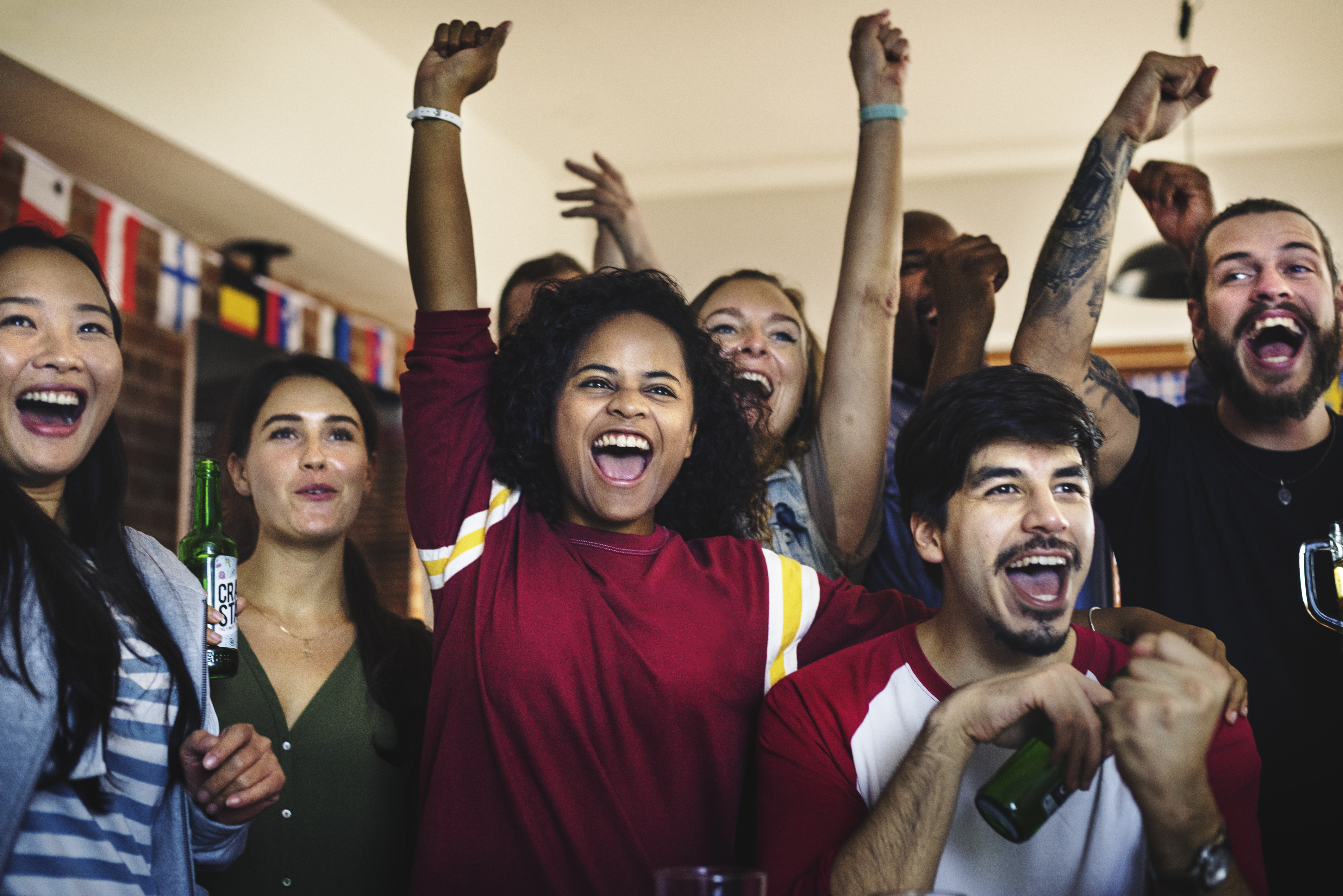 Frieds cheering sport at bar together - BARE International